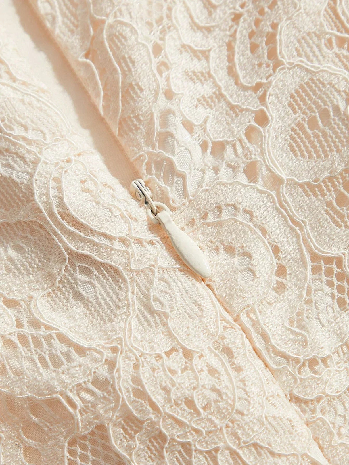 Delicate and romantic, this sleeveless dress features a soft blush color adorned with intricate lace patterns, showcasing an.