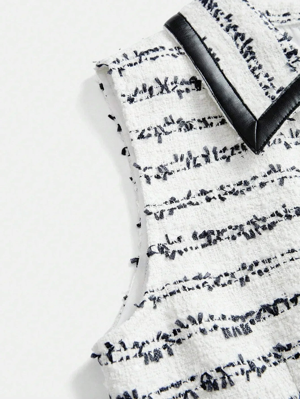 This chic sleeveless dress features a textured white fabric adorned with elegant navy stripes, creating a striking contrast..