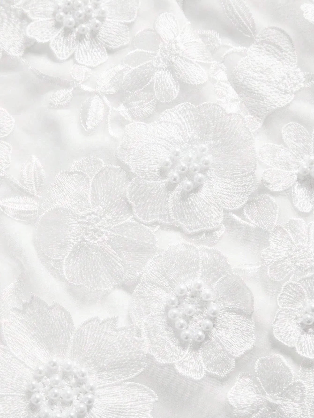 Elegant white dress featuring intricate floral embroidery and delicate pearl accents, creating a romantic and feminine.