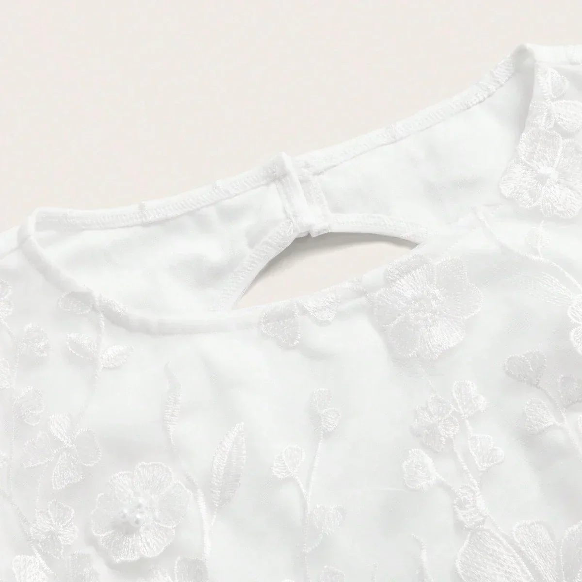 Delicate and chic, this white dress features intricate floral embroidery that adds a touch of elegance to its simple design..