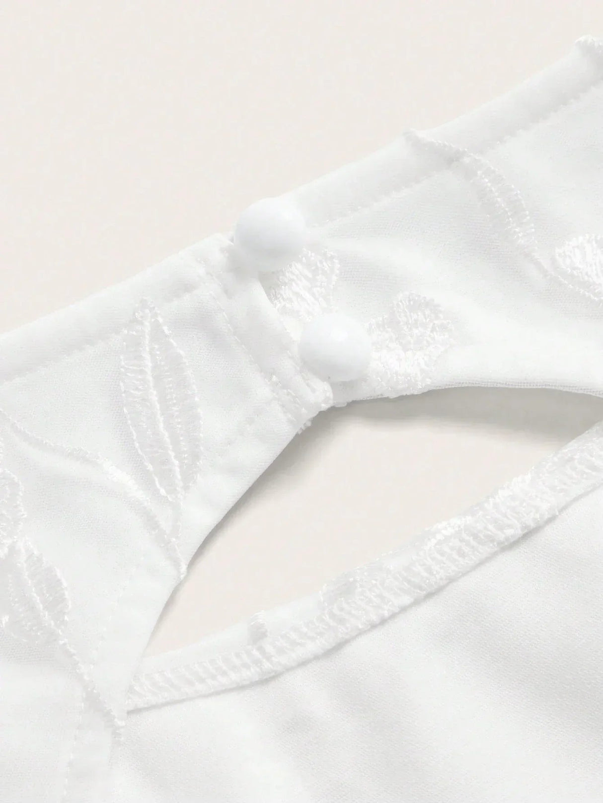 Discover the elegance of this white dress featuring intricate floral embroidery and a delicate button closure at the back..
