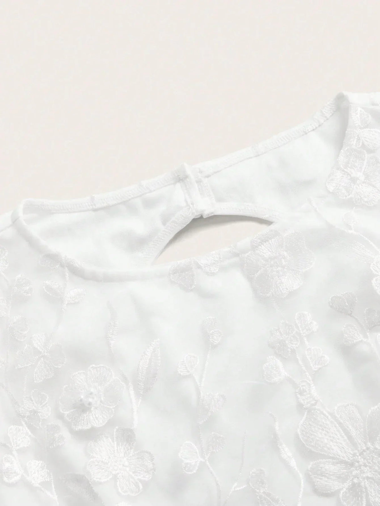 This delicate white dress features intricate floral embroidery, perfect for a romantic occasion. The elegant fit and.