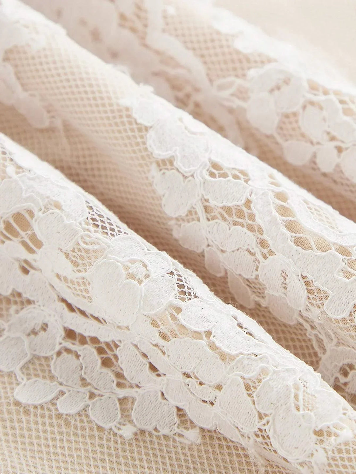 Delicate white lace features intricate floral patterns, lending a romantic touch to this elegant dress fabric. The.