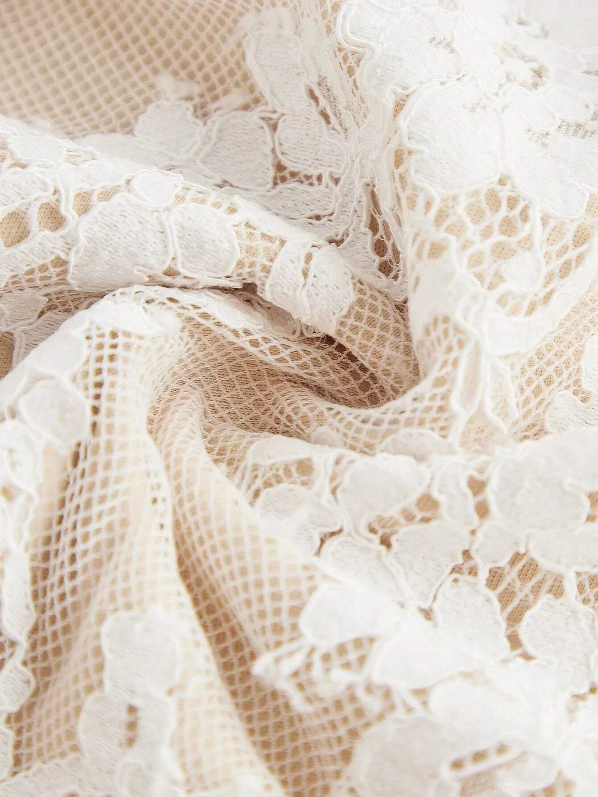 Delicate cream lace fabric with intricate floral patterns creates a romantic and ethereal look, perfect for a summer dress..
