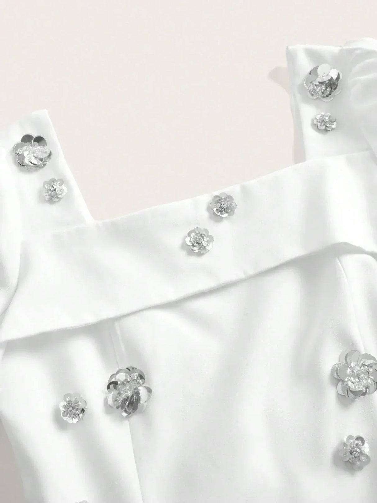 This elegant white dress features a flattering fit with delicate floral embellishments that add a touch of sparkle and.