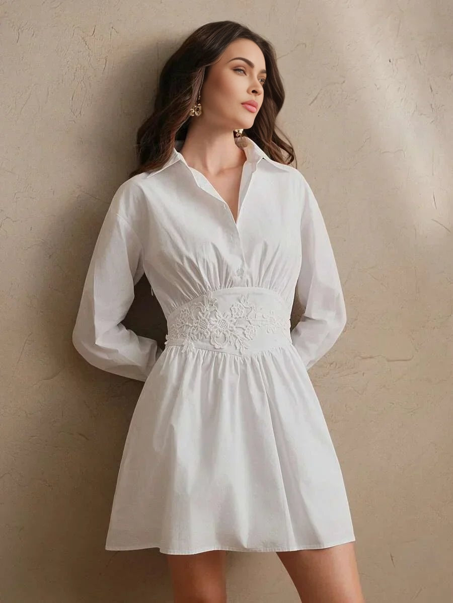 This chic white dress features a flattering fit-and-flare silhouette, accentuated by delicate floral embroidery at the waist.