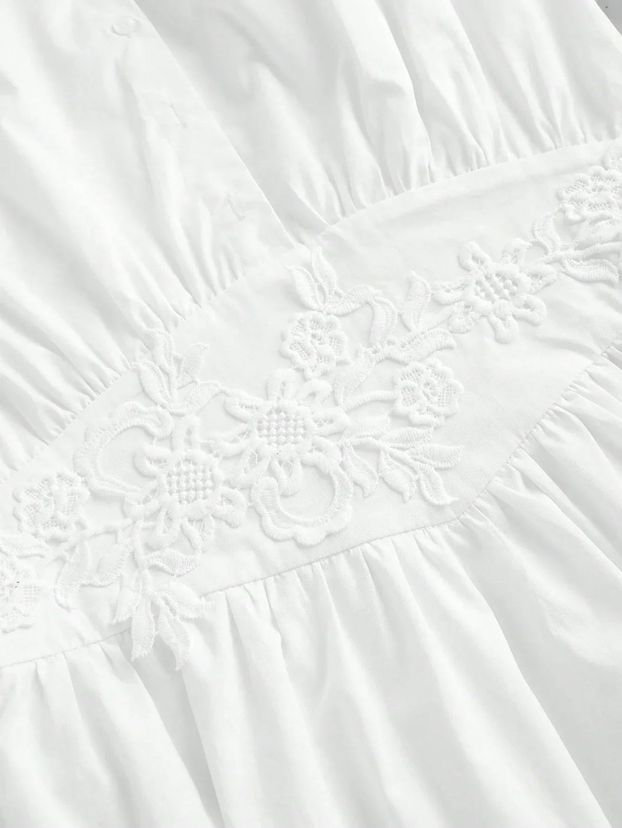 Charming and elegant, this white dress features delicate floral embroidery along the waistline, accentuating its soft,.