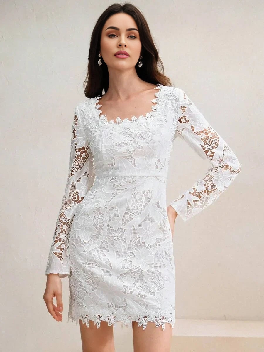 This elegant white dress features delicate floral lace with long sleeves and a flattering fitted silhouette, accentuated by.