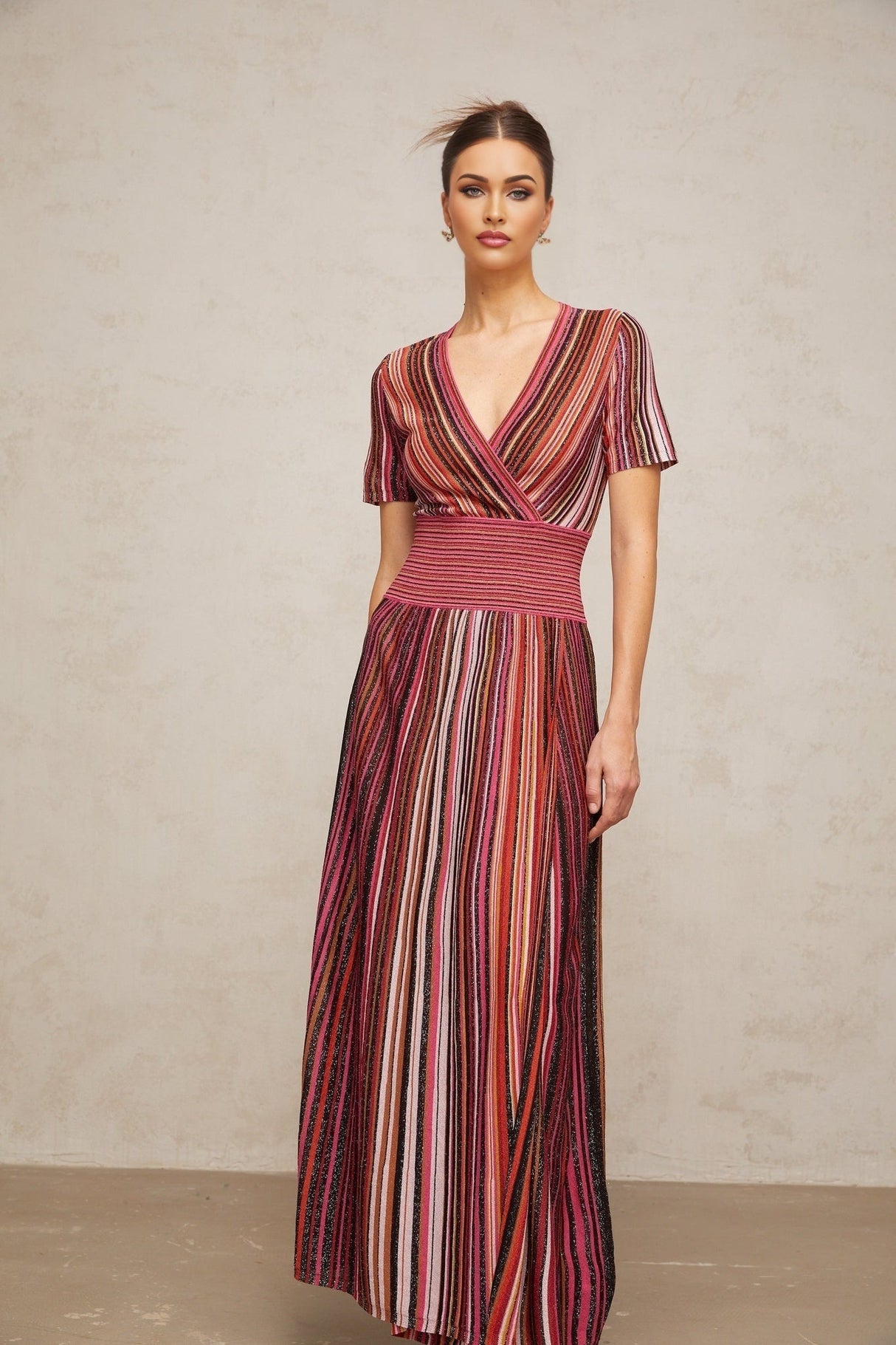 Woman wearing a long flowing multicolor metallic knit maxi dress with shimmering effect