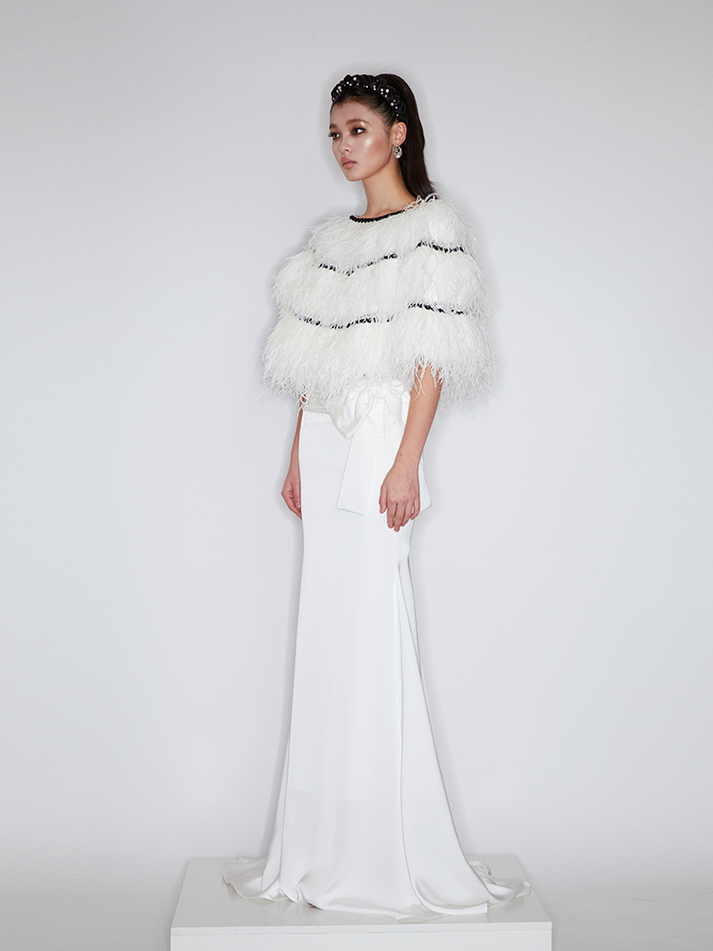 Sophia feather-embellished cape with tiered ostrich feathers, black trim accents, and a relaxed fit, crafted from lightweight polyester.