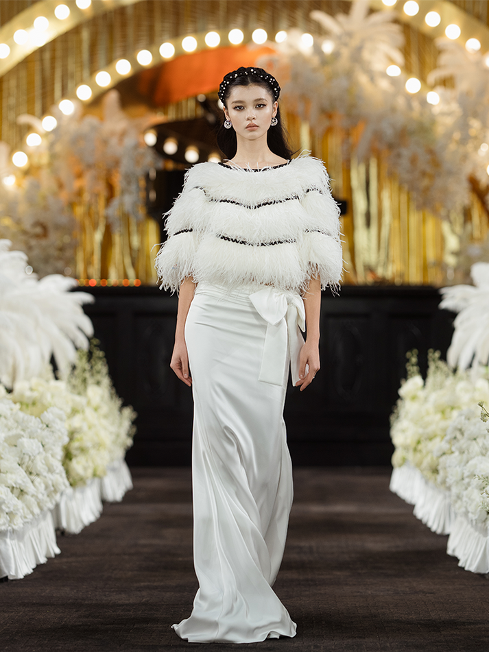Sophia asymmetric white evening dress with a delicate bow detail, flowing silhouette, and layered hemline, crafted from lightweight polyester.