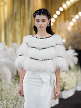 Sophia feather-embellished cape with tiered ostrich feathers, black trim accents, and a relaxed fit, crafted from lightweight polyester.