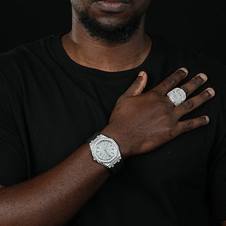 Man wearing a silver watch and ring on a black background