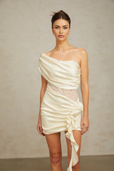 A beige asymmetric mini dress with lace panel details featuring a sleeveless design and fitted silhouette
