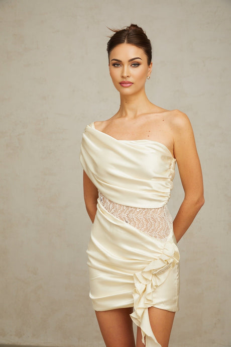 A beige asymmetric mini dress with lace panels featuring a neutral color palette and a delicate feminine design