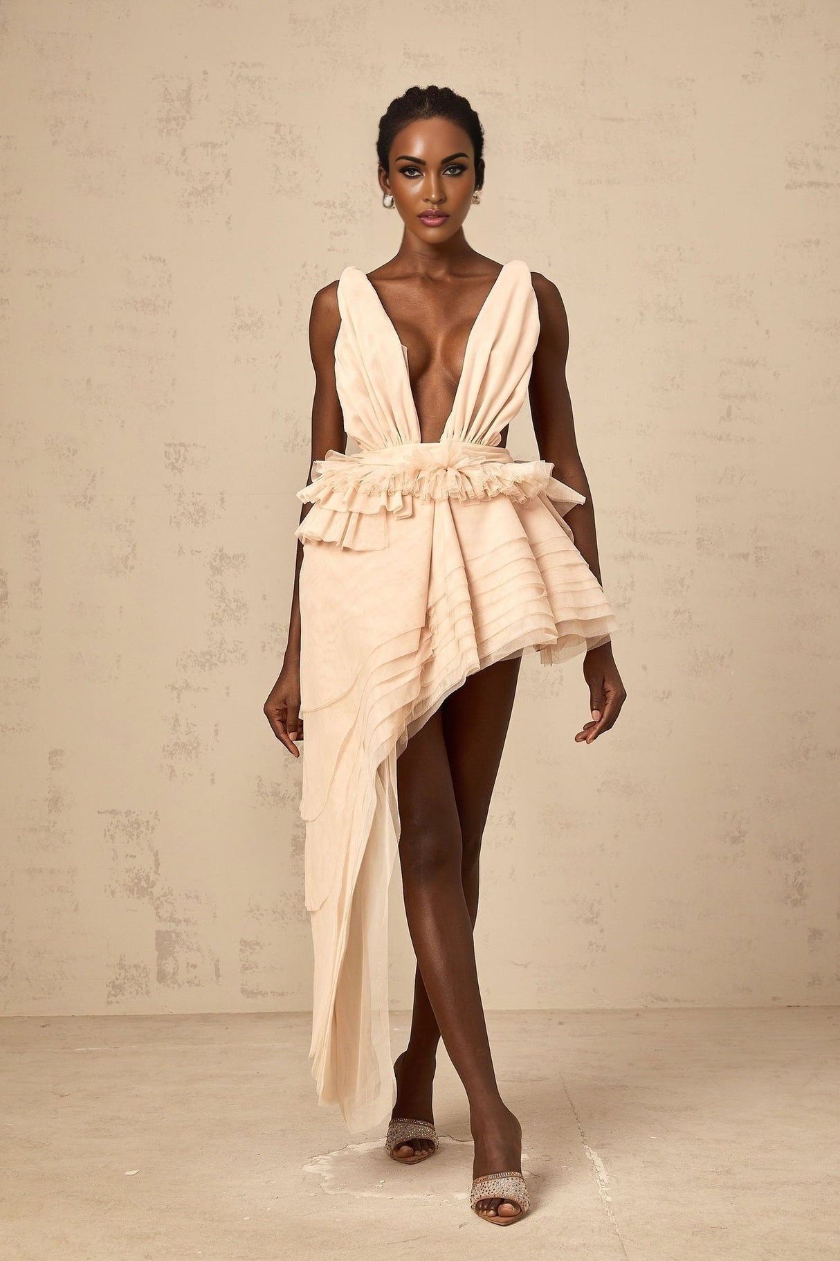 A beige asymmetric mini dress with ribbon design details and a flattering silhouette featuring neutral tones