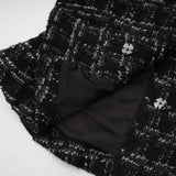 A black and white checked tweed matching set consisting of a sleeveless vest top and skirt in a classic pattern