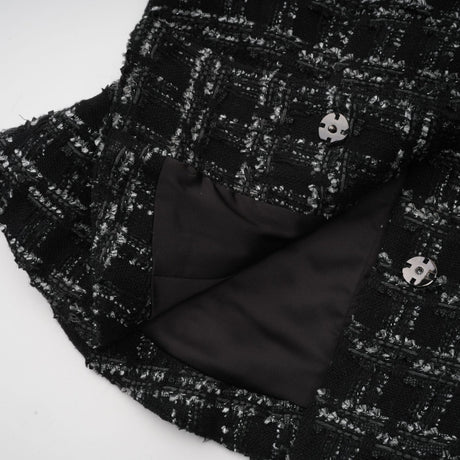 A black and white checked tweed matching set consisting of a sleeveless vest top and skirt in a classic pattern