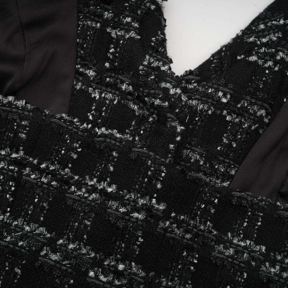A black and white checked tweed matching set featuring a sleeveless vest top and skirt in a classic pattern