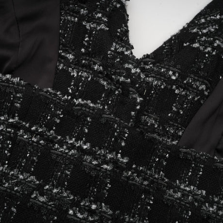 A black and white checked tweed matching set featuring a sleeveless vest top and skirt in a classic pattern
