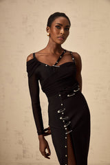 A black asymmetric midi dress with cutout details featuring a oneshoulder design and side slit on model against plain background