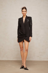 A black blazer dress adorned with sequins and embellishments featuring a tailored silhouette and shimmering details