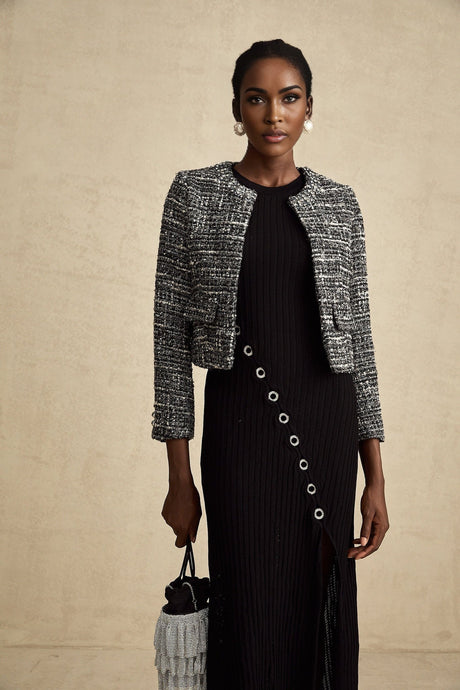 A black bouclé tweed jacket named Éloïse hanging on a clothing rack