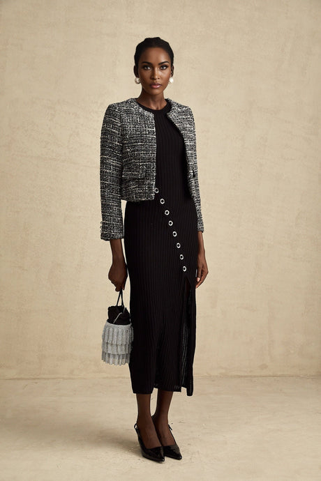 A black bouclé tweed jacket with a classic design featuring textured fabric and a tailored silhouette