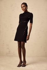 A black fineknit mini dress with decorative buttons featuring a design inspired by Wanda