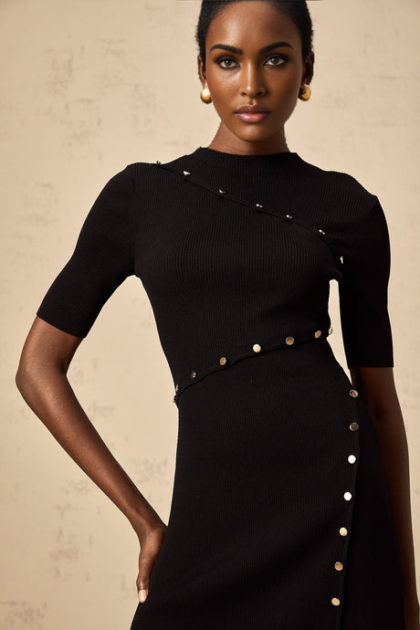 A black fineknit mini dress with decorative buttons worn by a model against a plain background