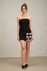 A black fitted mini dress with studded details and a decorative bowknot accent