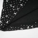 A black floor length maxi dress with sheer fabric and embellished details worn by a model