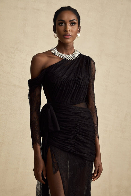 A black floorlength maxi dress with a single shoulder strap and a cut out detail on one side