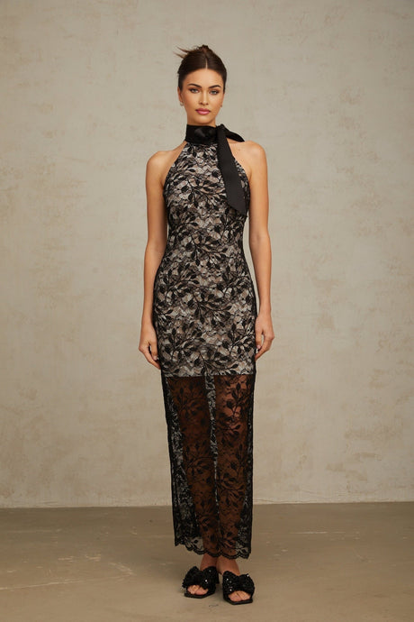 A black floral lace maxi dress with a halter neckline named Coralie featuring a long flowing skirt and delicate lace pattern throughout