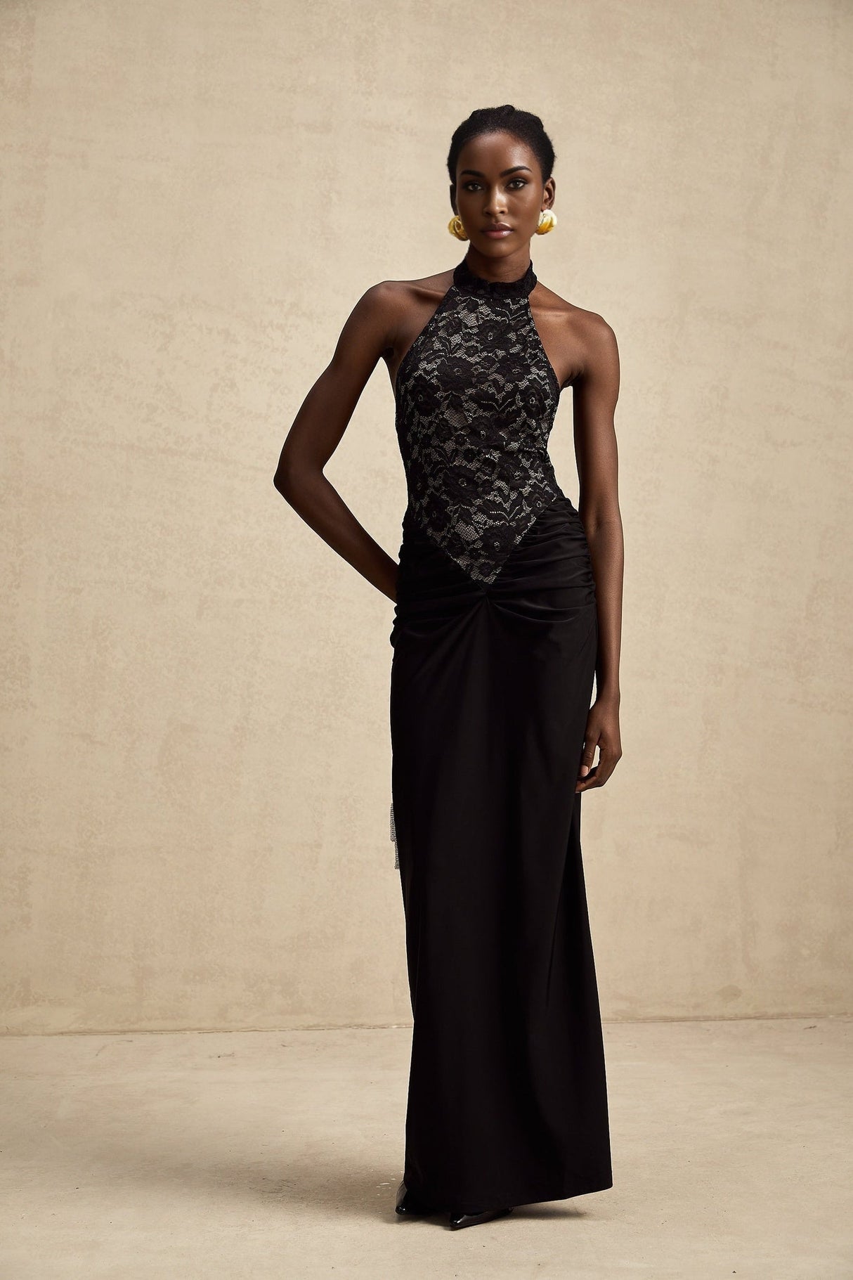 A black floral lace maxi dress with halter neckline named Camille featuring a long flowing skirt and intricate lace pattern throughout