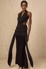 A black halterneck maxi dress with a backless design featuring a long flowing skirt and open back