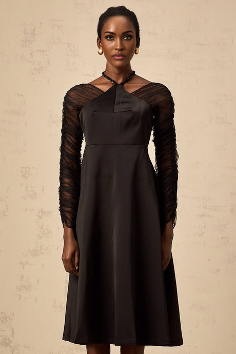 A black halterneck midi dress with panel detailing worn by a model against a plain background