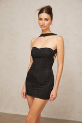 A black halterneck mini dress adorned with rhinestones featuring a design inspired by Thérèse worn by a model against a plain background