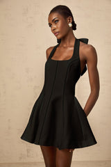 A black halterneck mini dress with a bow detail featuring a sleek and stylish design by Quirine