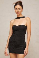 A black halterneck mini dress with rhinestone embellishments worn by a model against a plain background