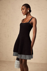A black knit mini dress with a flared skirt and studded details named Eliane