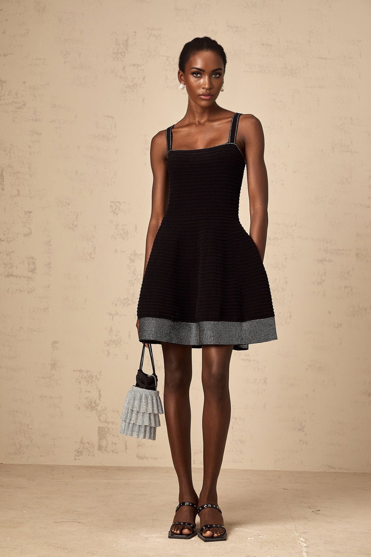 A black knit mini dress with flared skirt and studded details named Eliane