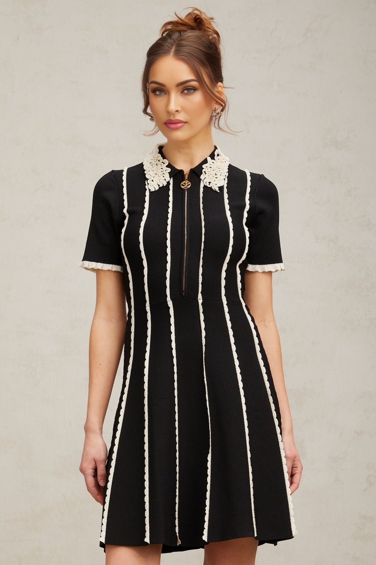 A black knit mini dress with vertical stripes and ruffle trim details named Zazie