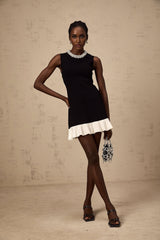 A black knitted mini dress with ruffled details and faux pearl embellishments named Elodie