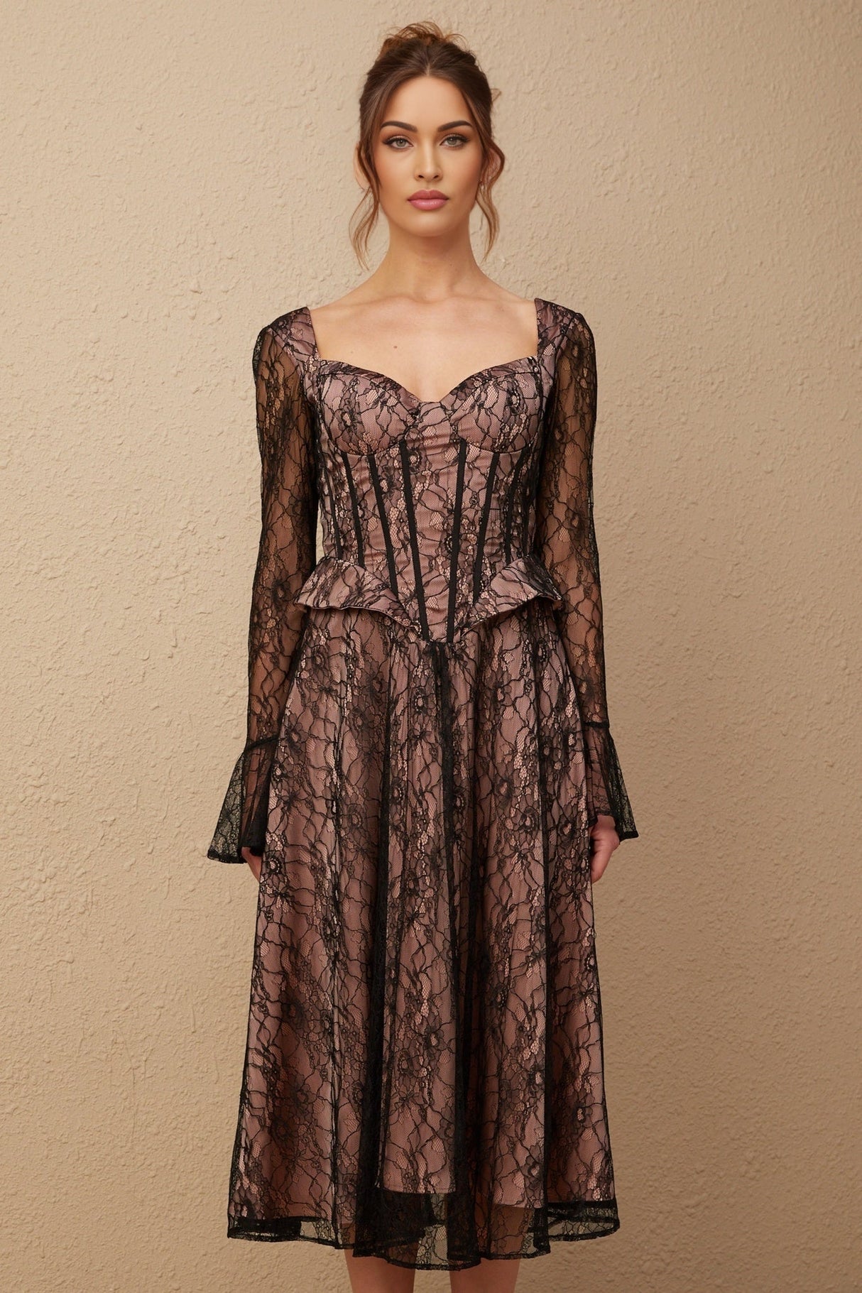 A black lace midi dress with a flared skirt named Jennifer worn by a model standing against a plain background