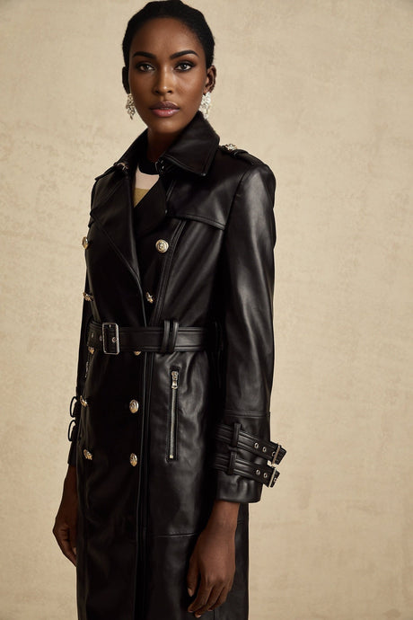 A black leather coat with double breasted front closure and belted waist featuring long sleeves and a lapel collar