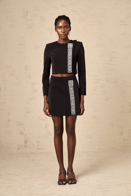 A black matching set consisting of a top and skirt adorned with crystal embellishments named Nadia