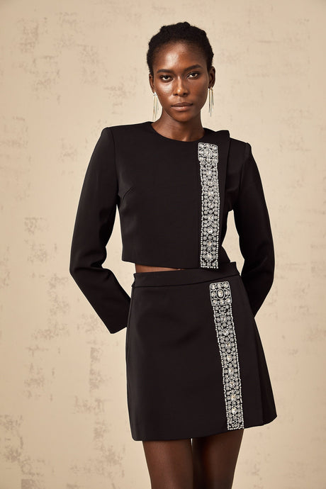 A black matching set consisting of a top and skirt embellished with crystal details named Nadia