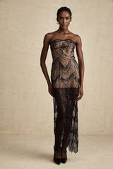 A black maxi dress with a sequinned corset bodice and sheer mesh skirt featuring long sleeves and a flowing silhouette