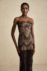 A black maxi dress with a sequinned corset bodice and sheer mesh skirt worn by a model standing against a plain background